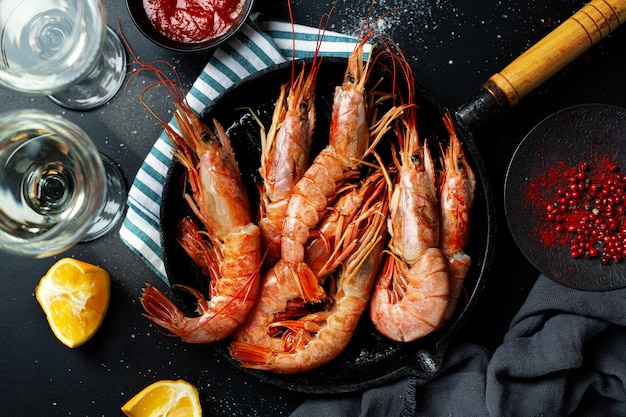 Uncooked giant shrimps on dark table