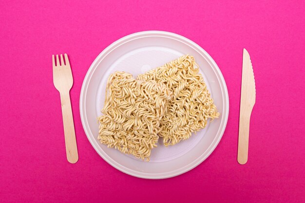 Uncooked instant noodles on white plate