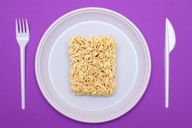 Uncooked instant noodles on white plate