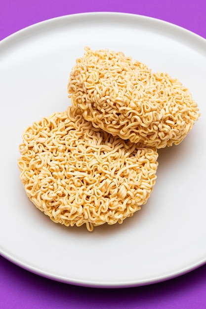 Uncooked instant noodles on white plate