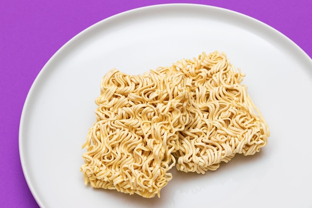 Uncooked instant noodles on white plate