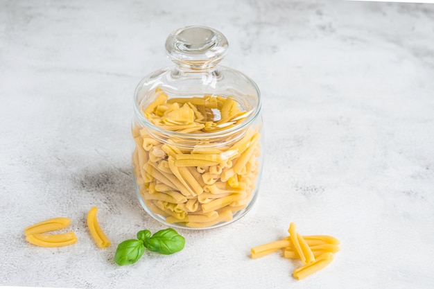 Uncooked italian pasta casarecce in a glass jar