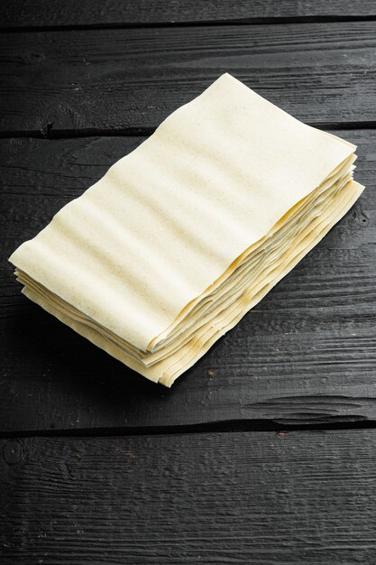 uncooked lasagna sheets set, on black wooden table