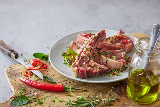 Uncooked marinated lamb chops on cutting board