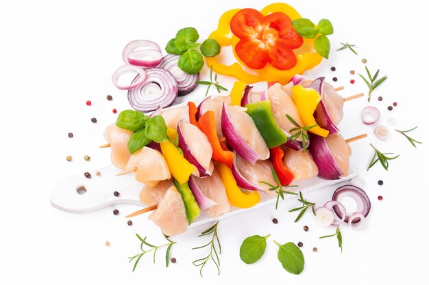 Photo uncooked mixed meat skewer with peppersraw chicken skewers with vegetables peppers onions on a white