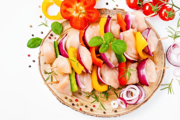 Photo uncooked mixed meat skewer with peppersraw chicken skewers with vegetables peppers onions on a white