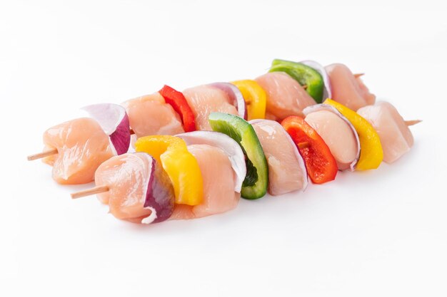 Uncooked mixed meat skewer with peppersskewers with pieces of raw meat red yellow and green pepperto