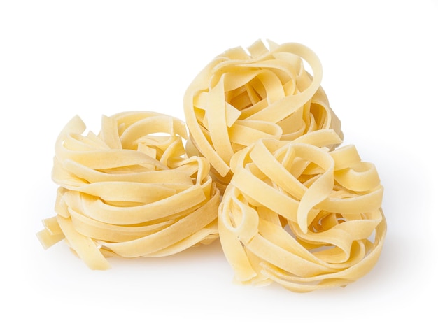 Uncooked nest of tagliatelle pasta isolated on white background with clipping path