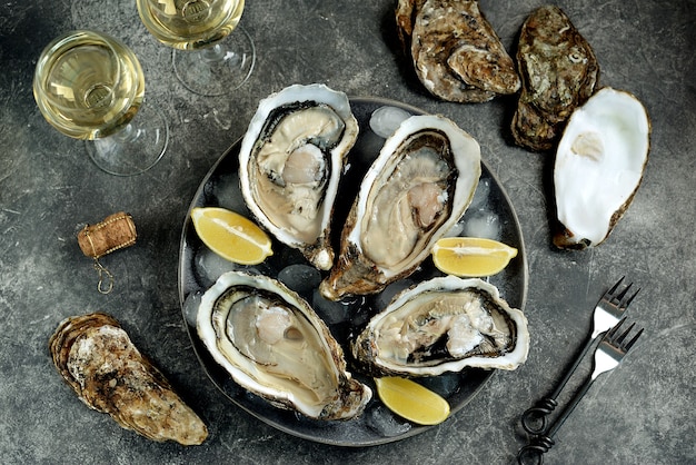 uncooked oysters in a shell with lemon on ice