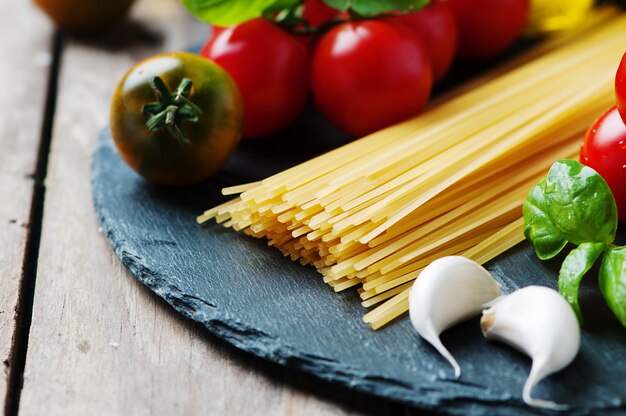 Uncooked pasta with tomato, basil and oil