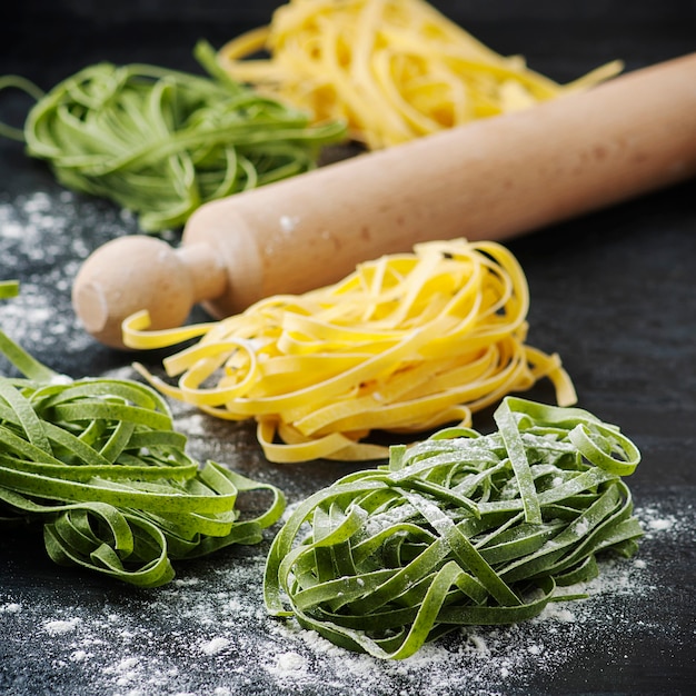 Uncooked pasta with wooden rolling pin