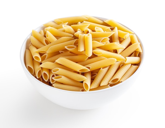 Uncooked penne pasta in white bowl isolated on white background with clipping path