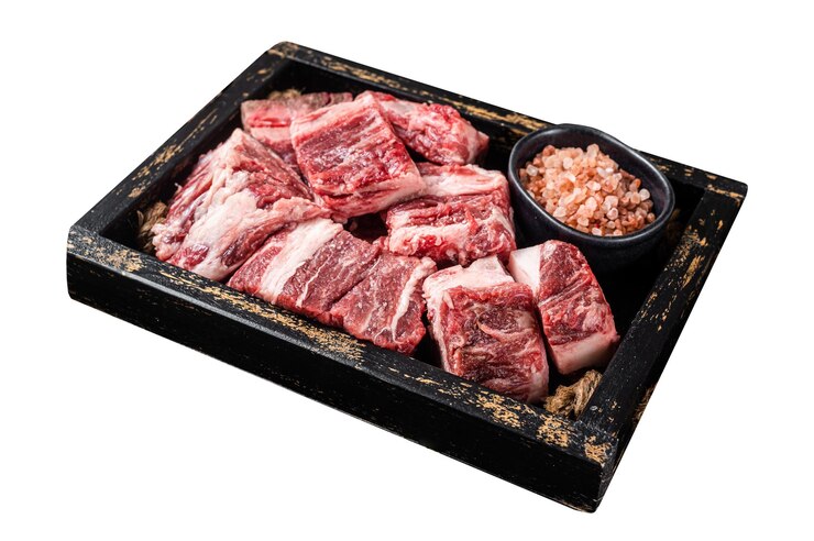Photo 소금과 티마이를 넣은 나무 트레이에 고기 고기 어진 원시 양고기 큐브 은  바탕에 고립되어 있습니다.