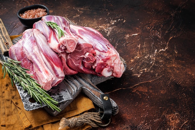 Uncooked Raw lamb mutton shanks on a butcher board Dark background Top view Copy space