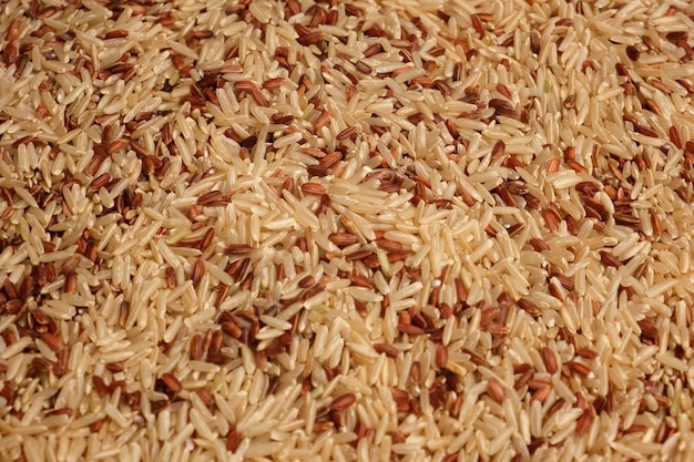 Uncooked red rice wallpaper. long brown rice surface. close up.\
grain stack. world crisis, export