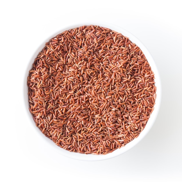 Uncooked red rice in white bowl isolated on white background with clipping path