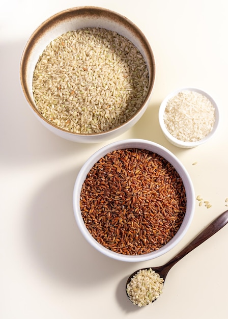 Uncooked rice assortment in bowl on white background Top view