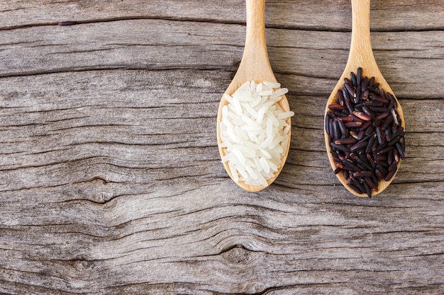 Uncooked rice in spoon, white and black rice. 