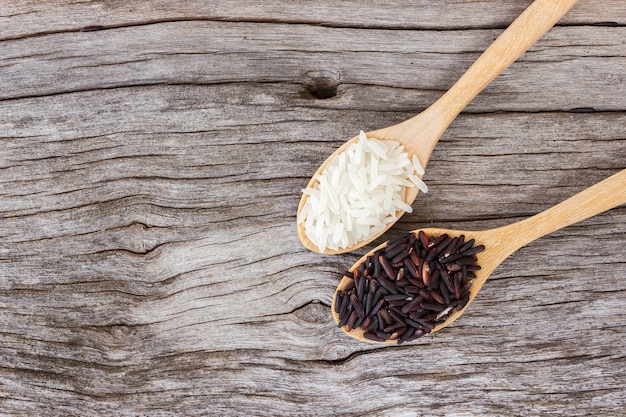 Photo uncooked rice in spoon, white and black rice.