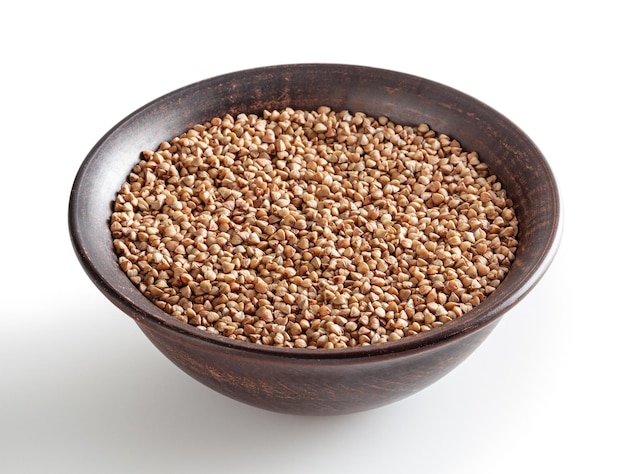 Uncooked roasted buckwheat in ceramic bowl isolated on white background with clipping path