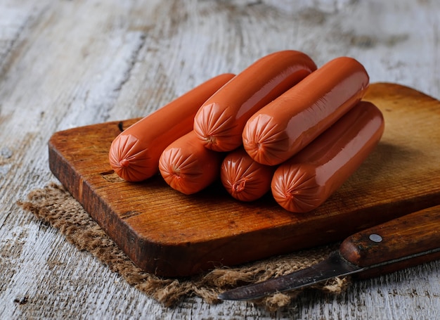 Uncooked sausages on wooden background