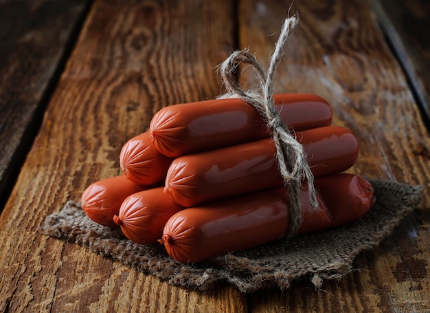 Uncooked sausages on wooden background