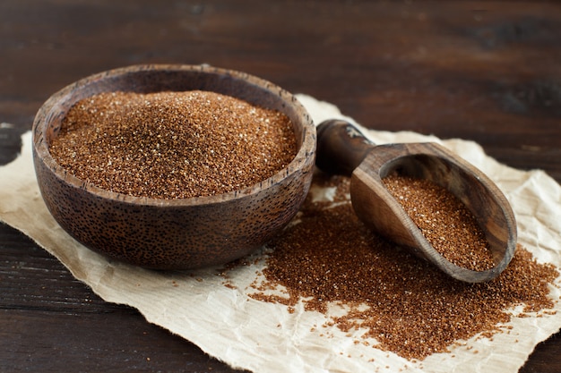 Uncooked teff grain in a bowl with a spoon close up