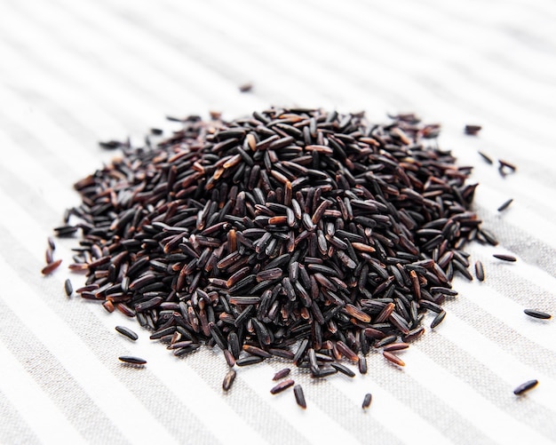 Uncooked wild rice on a white wooden surface