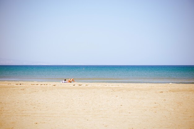 Undefined lady laying at the summer beach