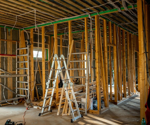 나무 프레임, 전기 배선 및 현장 사다리로 건설 중인 주택 내부