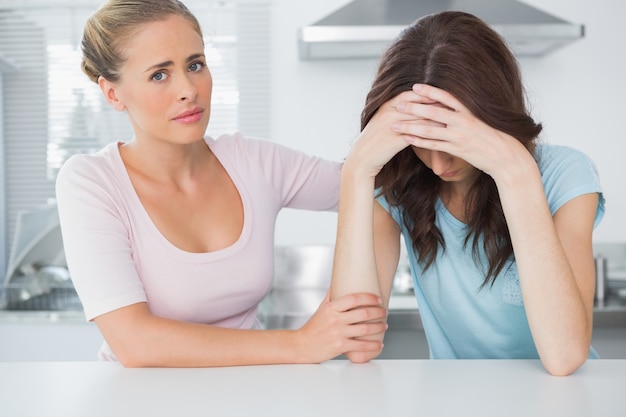 Understanding woman comforting her upset friend