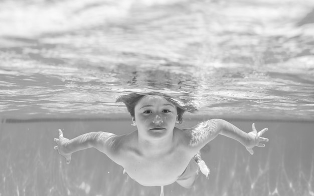 Foto bambino subacqueo in piscina ragazzo carino che nuota in piscina sott'acqua