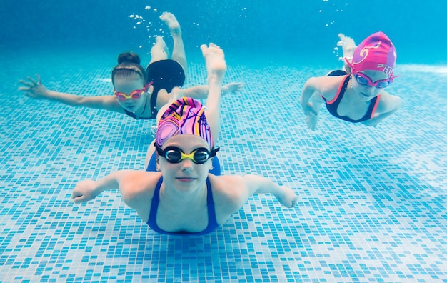 Foto subacquea di giovani amici in piscina.