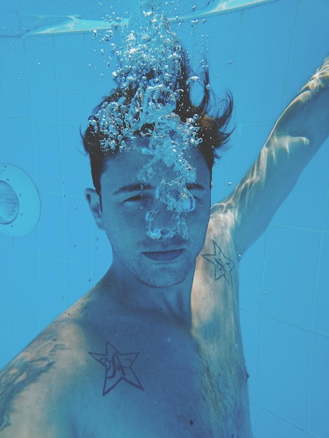 Photo underwater portrait of shirtless man in swimming pool