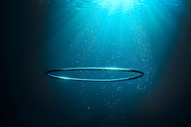 Photo underwater shot of big air bubble ring in deep transparent sea with shiny light during summer day