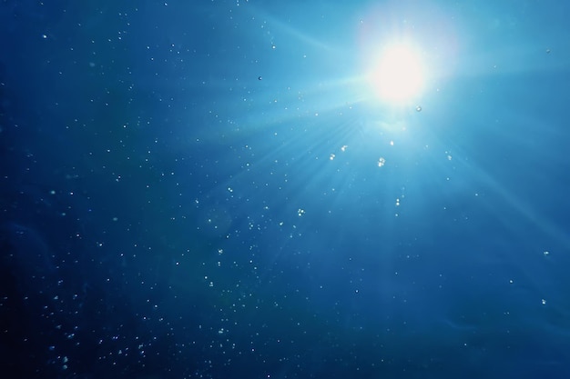Luce solare subacquea attraverso la superficie dell'acqua, sfondo subacqueo