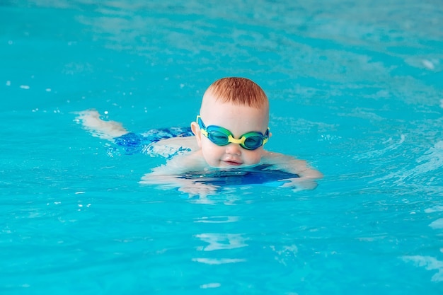 スイミングプールの水中の若い友人