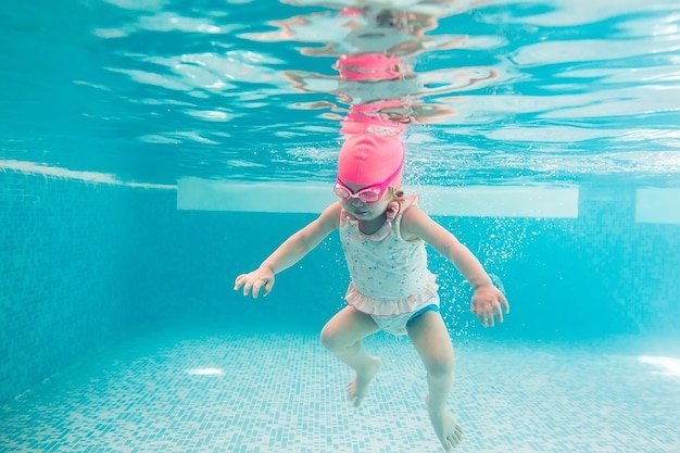 スイミングプールの水中の若い友人