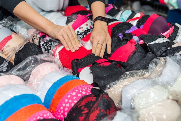 Underwear shop, female hands with colourful bras