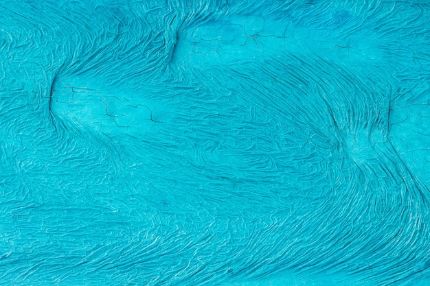 Unevenly painted surface of blue color with cracks