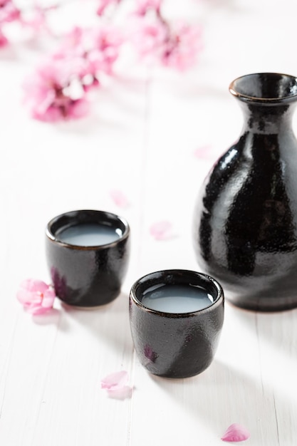 Unfiltered white sake sake with flowers of blooming cherry