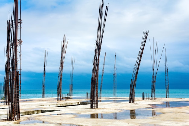 Unfinished building with protruding rebar on the seashore