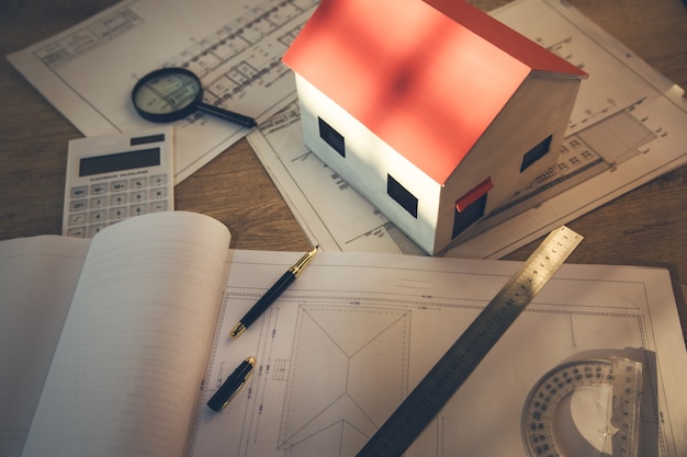 Unfinished house and documents on the table background