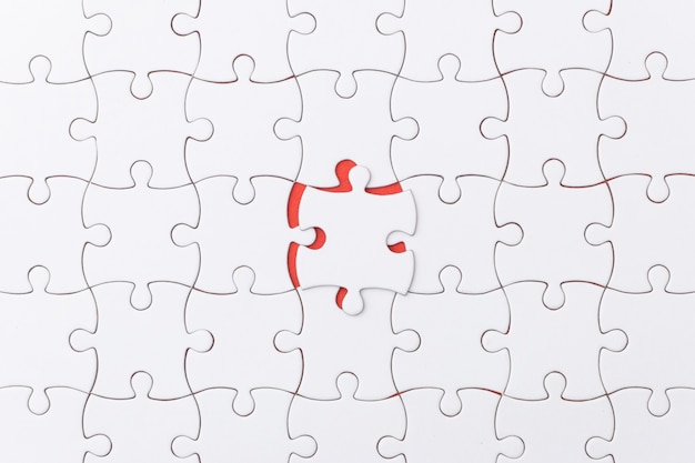 Unfinished jigsaw puzzle texture on red background.