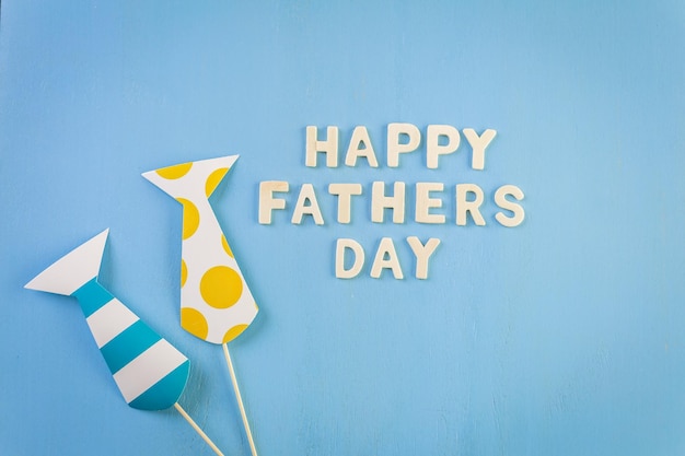 Unfinished wood lettrs sign Happy Father's Day on a painted wood background.