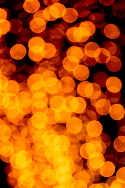 Unfocused abstract orange bokeh on black background. defocused and blurred many round light.