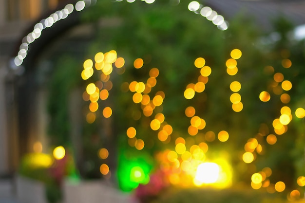 Unfocused lights called bokeh in the garden. Yellow and green colors main