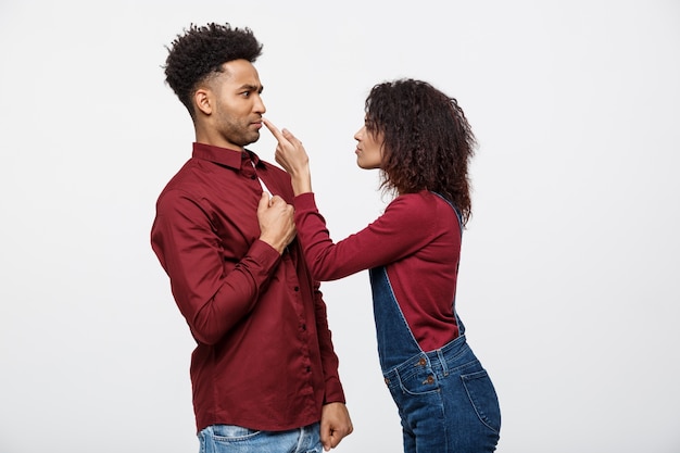 Unhappy African American couple in casual clothes arguing and figthing.