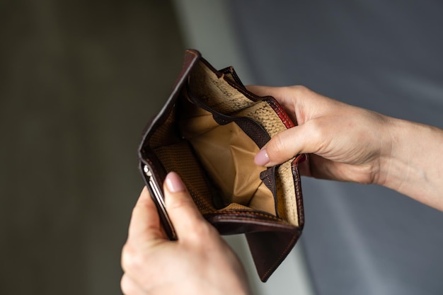 Unhappy bankrupt woman with empty wallet. Young woman shows her empty wallet. Bankruptcy.