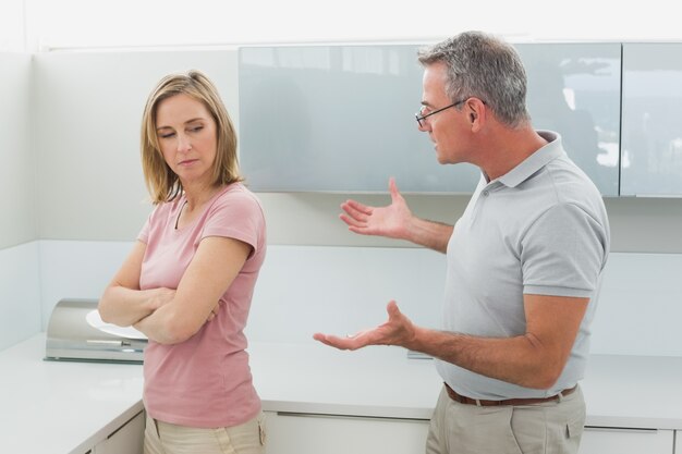 Unhappy couple having an argument in kitchen